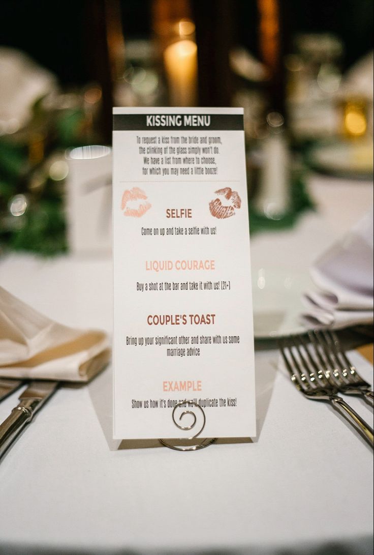 a white table with silverware and menus on it