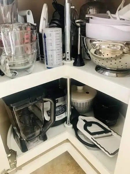 the corner of a kitchen cabinet filled with appliances