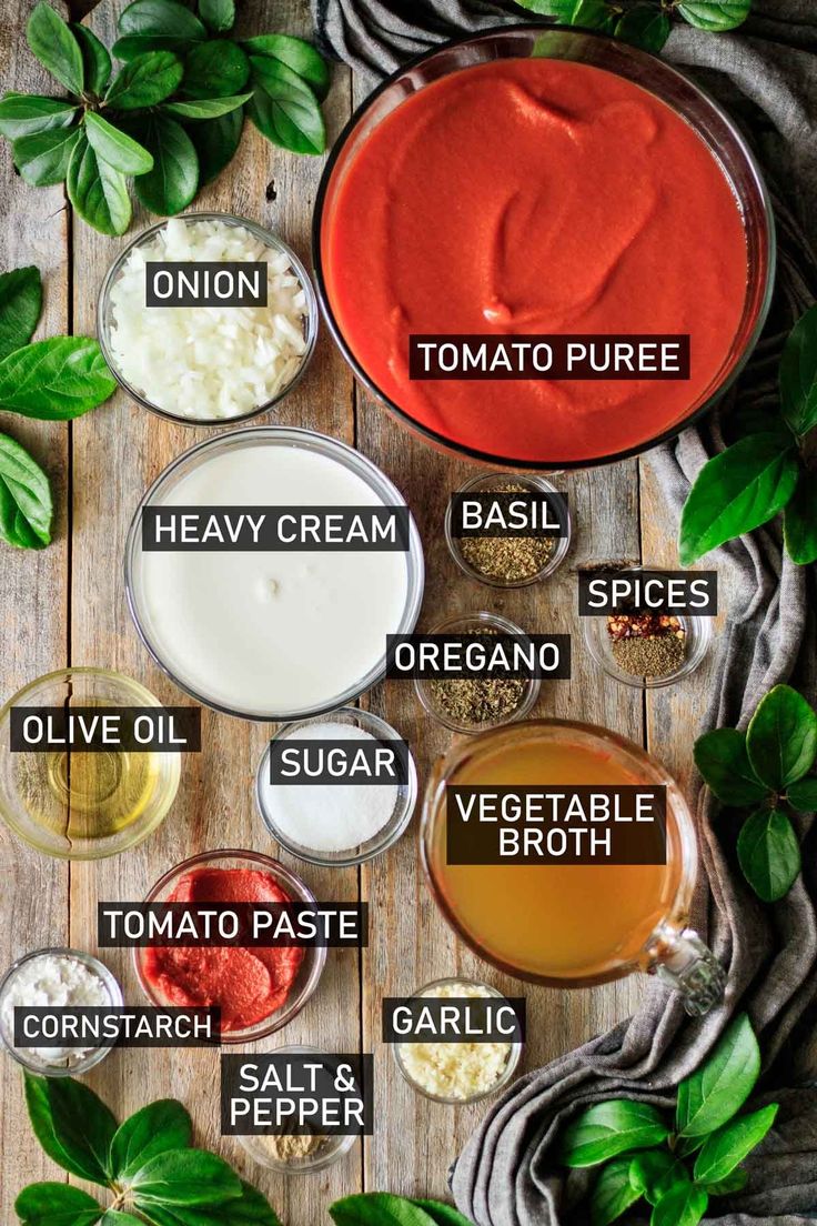 different types of sauces and condiments on a wooden table with green leaves