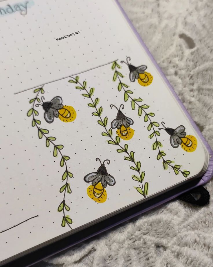 an open planner with bees and leaves on it