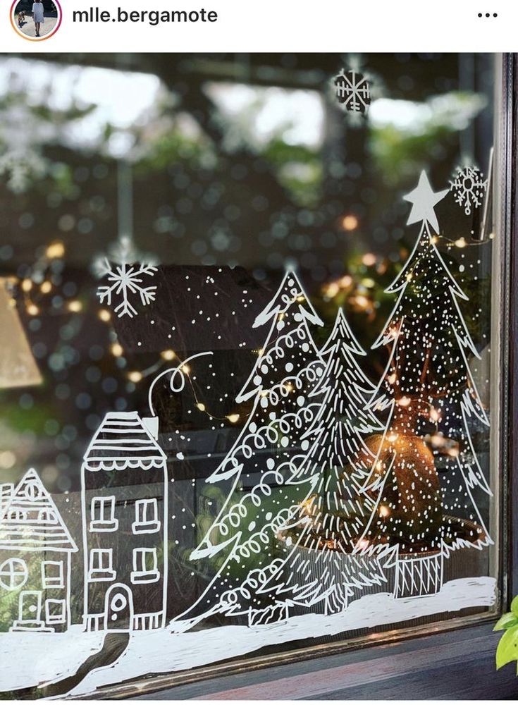 the window is decorated with christmas trees and snowflakes