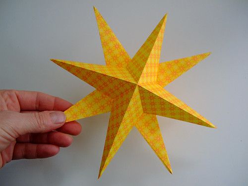 a hand is holding an origami star