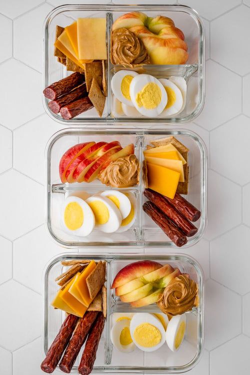 three glass containers filled with different types of food on top of a white countertop