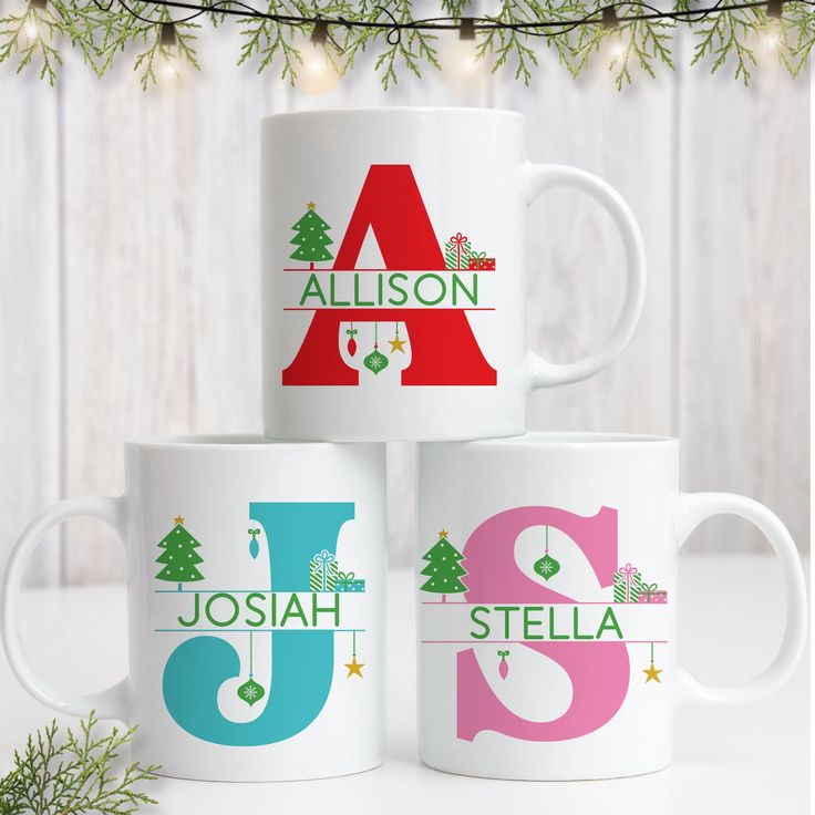 three personalized coffee mugs sitting next to each other in front of a christmas tree