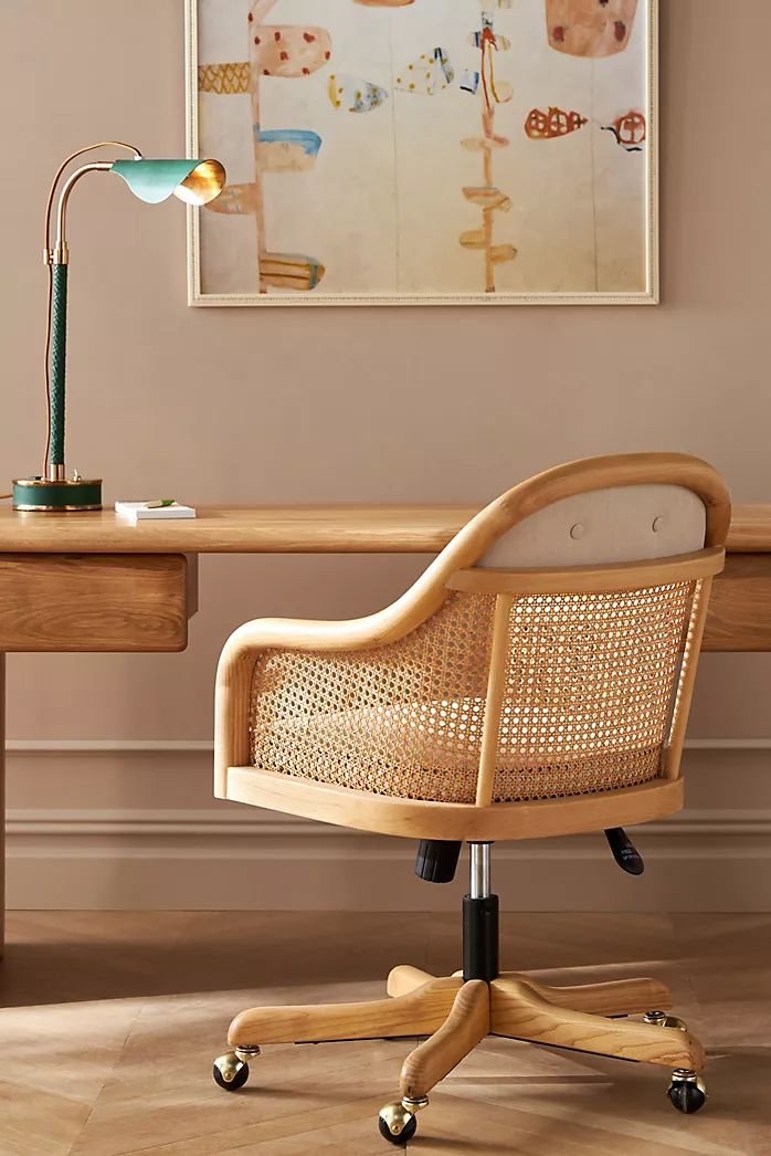 an office chair sitting in front of a desk with a lamp on top of it