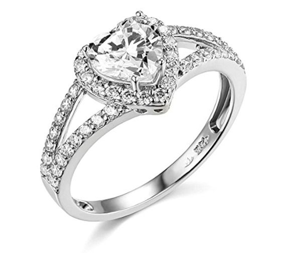 a white gold ring with an oval cut diamond and pave set shoulders