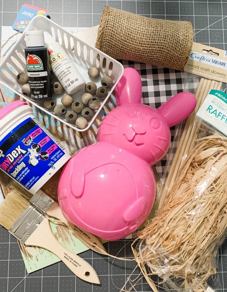 the contents of a crafting kit including eggs, yarn, and other items are laid out on a table