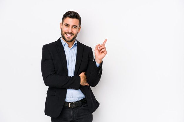 a man in a business suit standing with his arms crossed and smiling at the camera