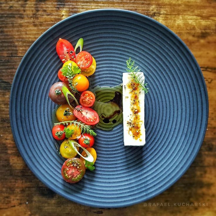 a blue plate topped with lots of different types of food on top of a wooden table