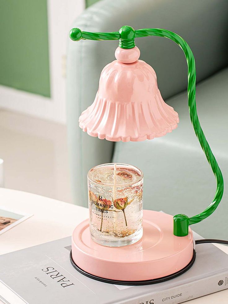 a pink table lamp with a green cord on it and a glass jar in the middle