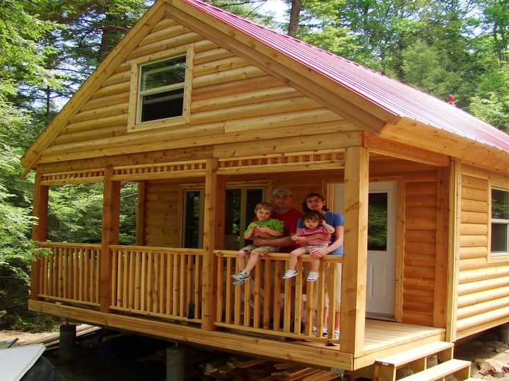 two people sitting on the porch of a small cabin