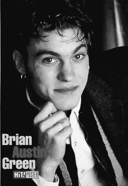 a black and white photo of a man in a suit with his hand on his chin