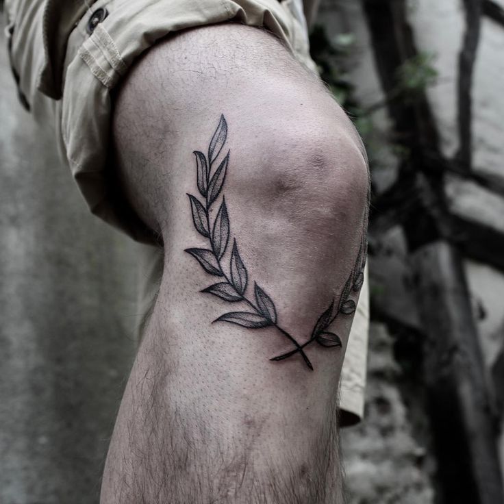 a man's arm with a tattoo on it that has a branch in the middle