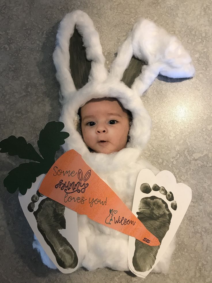 a baby dressed up as a bunny holding a carrot