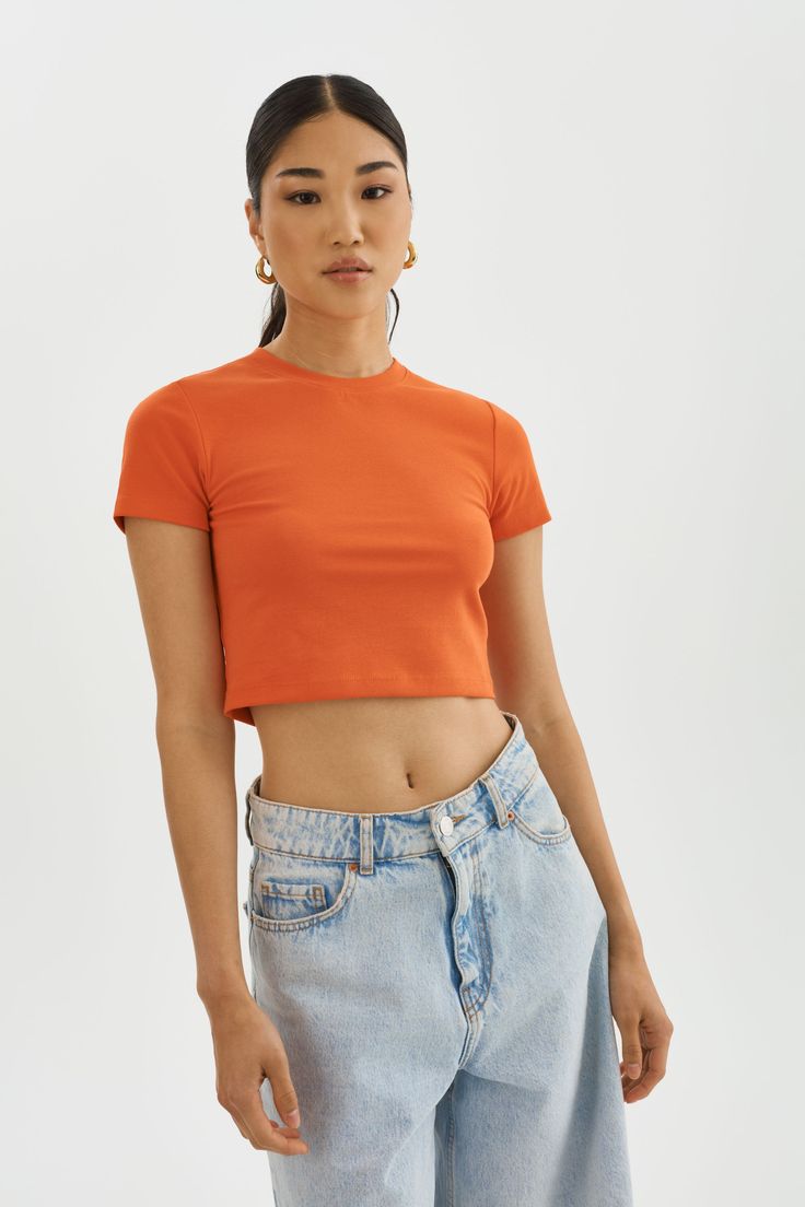 Elevate your basics with the INGA cropped t-shirt. The shortened length is perfect for a laid-back vacation atmosphere. It effortlessly pairs with various bottoms, from shorts and skirts to jeans or casual trousers, allowing you to create different looks with minimal effort. Orange Tshirt Outfits, Orange Tshirt, Orange Crop Top, Cropped T Shirt, Tshirt Outfits, Casual Trousers, Crop Tshirt, Rib Knit, Trousers