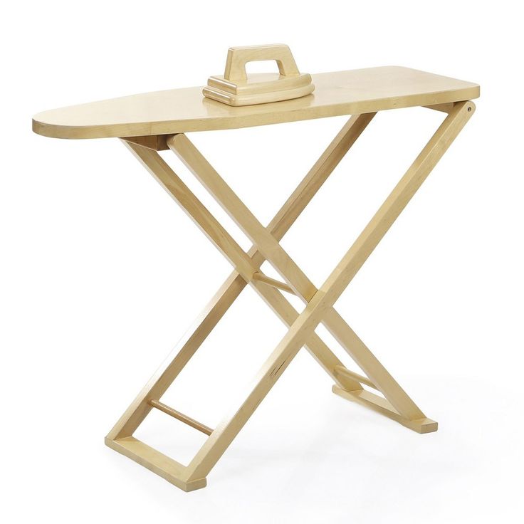 an ironing board on a wooden folding table with a bottle opener sitting on top