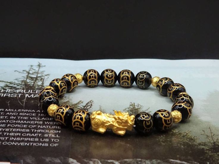 Gift yourself or your loveonce this beautiful Pure Gold Feng Shui Pixiu Bracelet.  *Materials: Au999 Pure Gold, Onyx Stone *Karat: 24K Pure Gold  *Gold Color: Yellow *Gold Weight: Approximately 1.71g - 1.75g SIZE Pixiu Length: .82 Inches Pixiu Width: .38 Inches Mantra Ball: 6mm Onyx Stone: 10mm 🔸️Pi Xiu has the meaning of bringing in wealth and treasure. Of course, it is capable of warding off evil spirits and bringing good fortune.  🔸️Money Ball is used to attract good fortune and money luck, Gold Spiritual Crystal Bracelet For Gift, Luxury Gold Beaded Bracelet For Gift, Spiritual Round Gold Bracelets, Gold Spiritual Bracelets, Gold Spiritual Crystal Bracelet, Luxury Bracelets For Festivals As Gifts, Luxury Bracelets For Festivals Gift, Symbolic Gold Bracelets For Festivals, Gold Crystal Bangle Bracelet For Gift