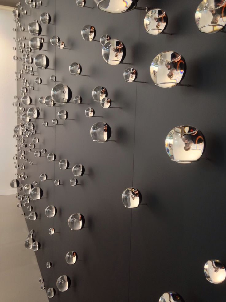 black and white photograph of multiple circular mirrors on the wall in front of a window