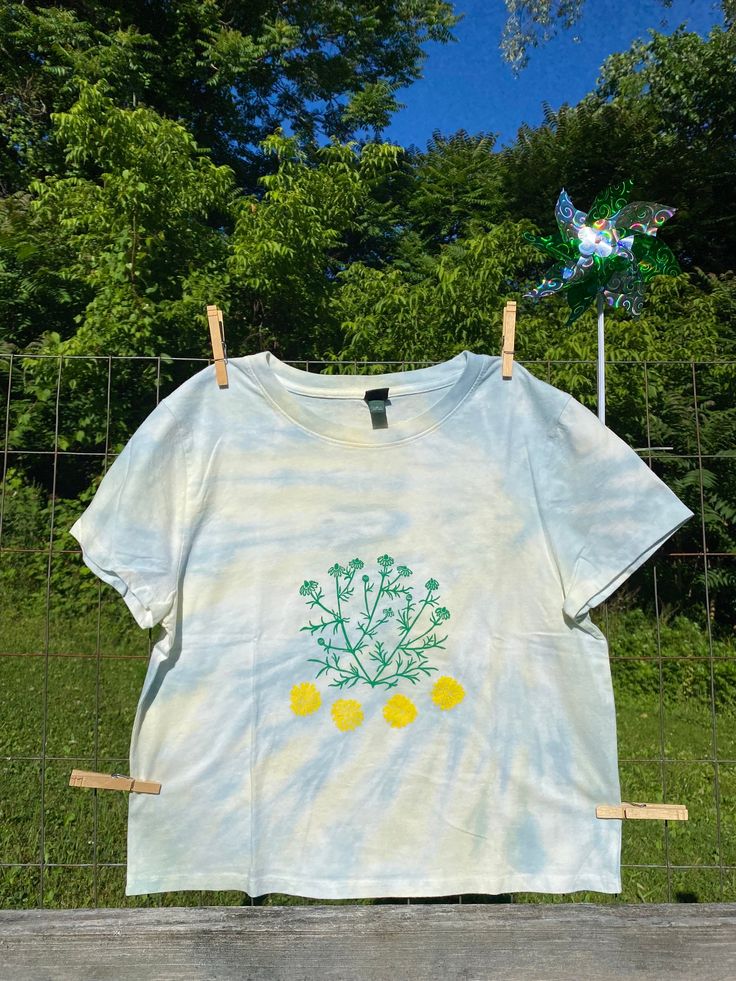 Chamomile & Calendula for a sweet summer tshirt🌞 100% cotton This item is new (not thrifted/gently used) Care Instructions: Cold, gentle cycle, tumble dry low or hang to dry to prevent shrinking *Note there will be some variations in printing as these are one of a kind and printed by hand.  This can include variations in the appearance of ink, slight smudging, or small ink markings out of the picture. Cotton T-shirt For Spring And Summer, Tie Dye Floral Print Top For Summer, Acid Wash Cotton Tops For Summer, Cotton Daisy Print Tops For Spring, Acid Wash Screen Print Tops For Spring, Acid Wash Screen Print Top For Summer, Organic Cotton Screen Print Tops For Summer, Acid Wash Screen Print Tops For Summer, Summer Tie Dye Tops With Screen Print