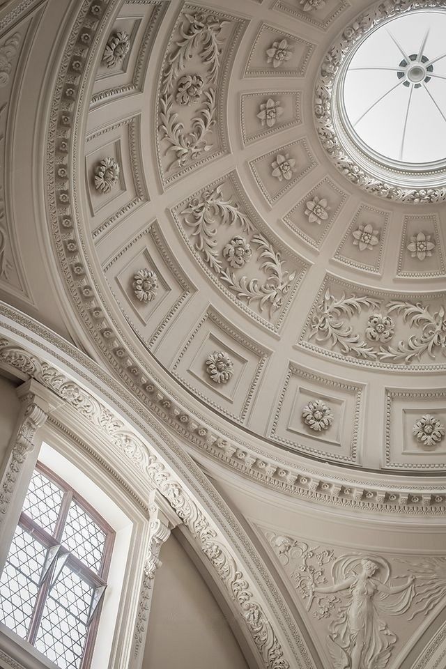 an ornate ceiling with a circular window in the center