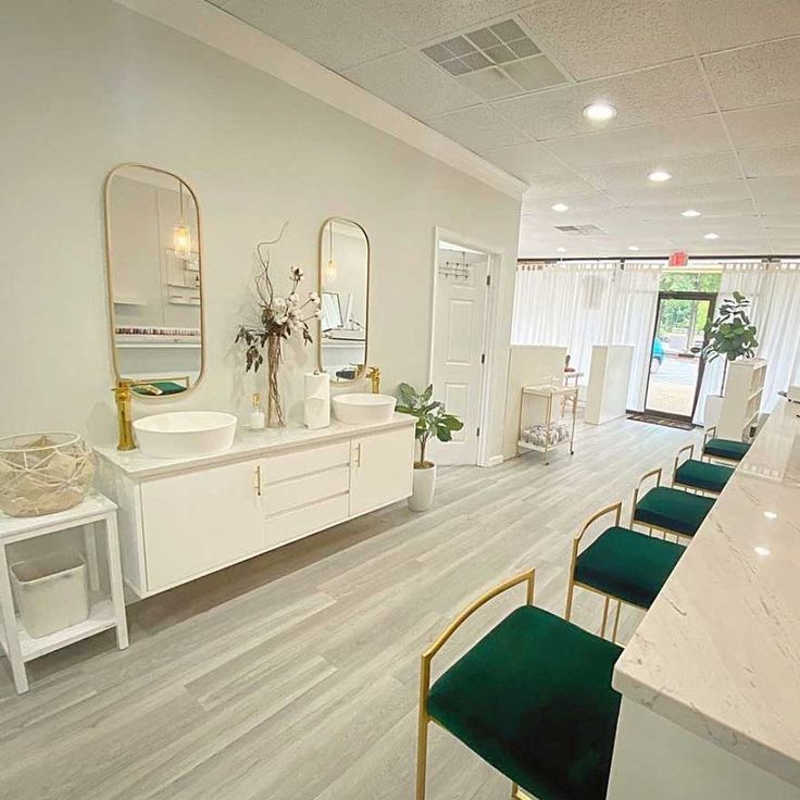 the interior of a salon with white counter tops and green chairs