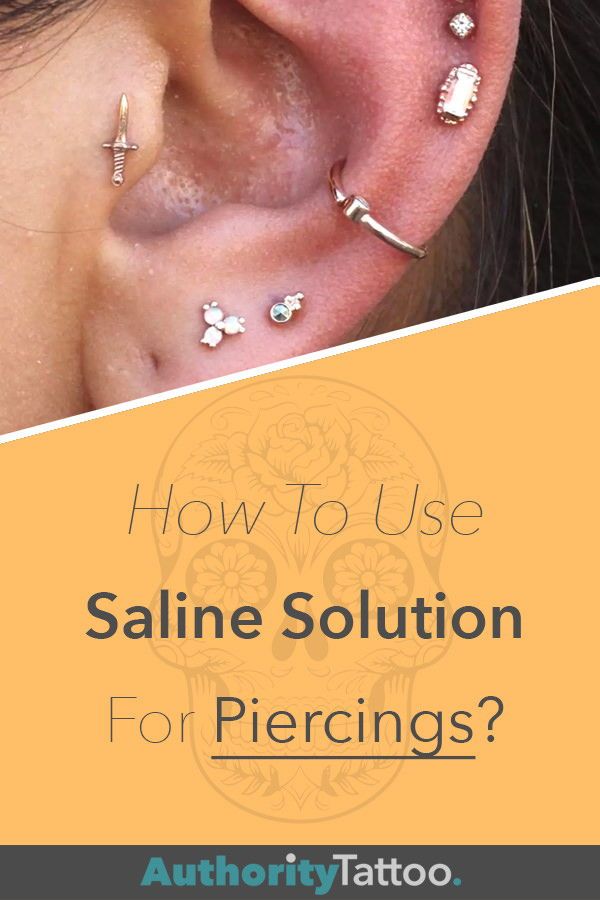 a woman's ear with the words how to use saline solution for piercings?