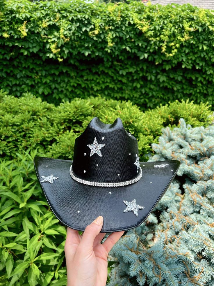 "Lucky Stars cowgirl hats come in all colors!  Message me about custom designs and colors!  Hats come in size S/M (measures 22 1/2 inches around crown) and M/L (measures 23 3/8\" around crown).  Every hat is handcrafted from start to finish. Slight variation in the appearance of each uniquely made item is to be expected. All Howdy Mear hats are made to order and take 1-2 weeks to ship. If you need your hat by a specific date, please message me to ensure it will arrive in time. *I use an industri Star Cowgirl Hat, Colored Cowboy Hats, Taylor Swift Cowboy Hats, Black Bedazzled Cowboy Hat, Cowgirl Hats Black, Unique Cowboy Hats, Bejeweled Cowboy Hat, Cowboy Hat Eras Tour, Cowgirl Hats Decorated