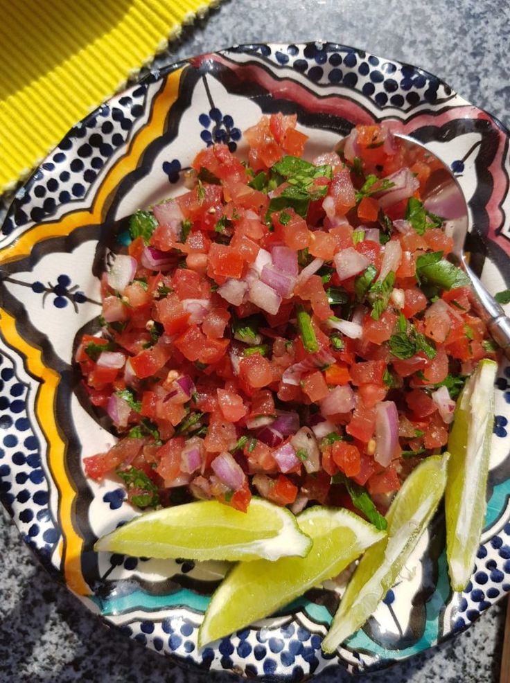 a colorful plate filled with sliced up vegetables on top of a blue and yellow table cloth