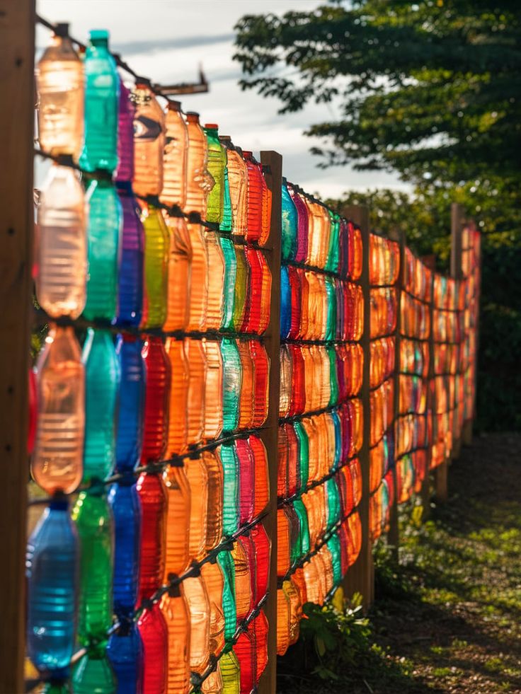 colorful plastic cups are lined up on a fence