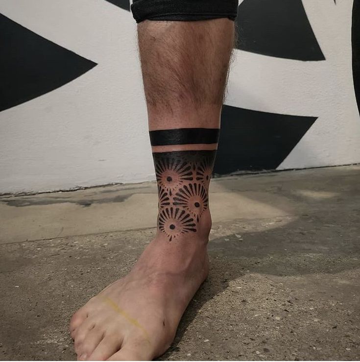 a man's foot with a tattoo on the side of his leg and an intricate design