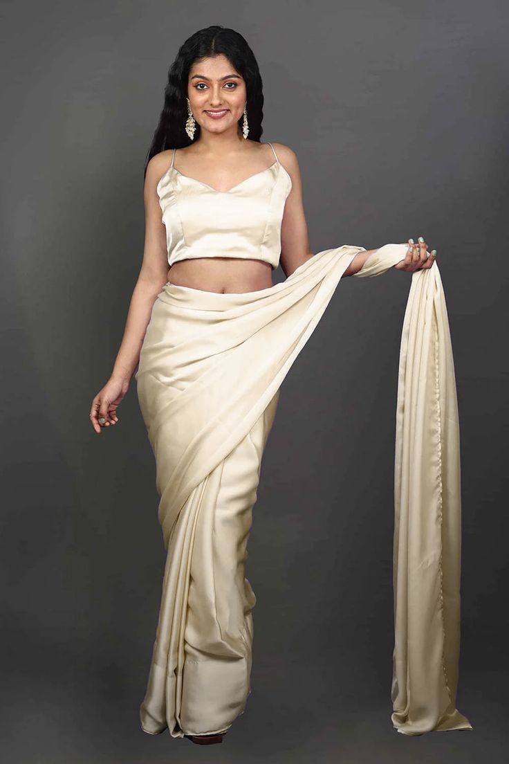 Experience the epitome of elegance with our Tia Cream Monochrome Cream One Minute Saree, crafted from luxurious satin fabric. Wear this luxurious saree for your next event or adorn your besties in this as the perfect Bridesmaid's saree! The saree's rich texture and delicate drape create a mesmerizing silhouette that exudes grace and sophistication. Perfect for special occasions or festive celebrations, this saree adds a timeless charm to your ensemble, making you the center of attention. Product Silk Draped Choli For Wedding, Silk Pre-draped Saree For Wedding, Semi-stitched Silk Draped Blouse Piece, Semi-stitched Draped Silk Blouse Piece, Draped Art Silk Blouse Piece For Wedding, Fitted Raw Silk Pre-draped Saree For Evening, Semi-stitched Draped Silk Saree, Draped Art Silk Dupatta For Party, Party Wear Draped Art Silk Dupatta