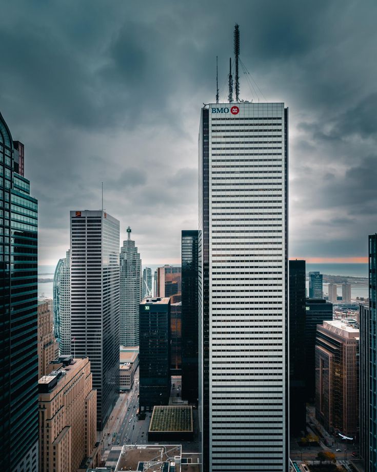 an aerial view of the city with skyscrapers and cloudy sky in the foreground