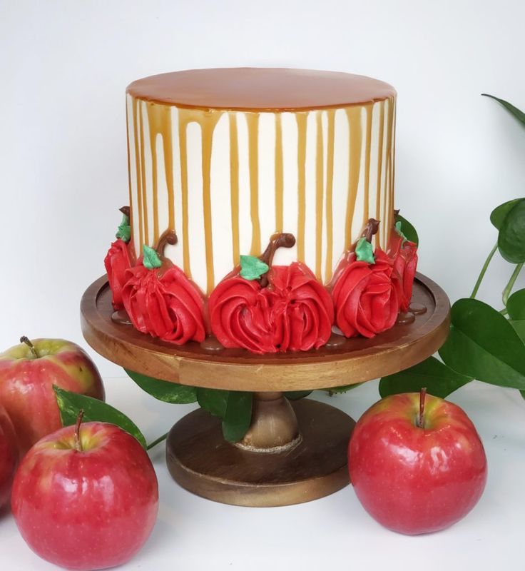 there is a cake with roses and apples on the table