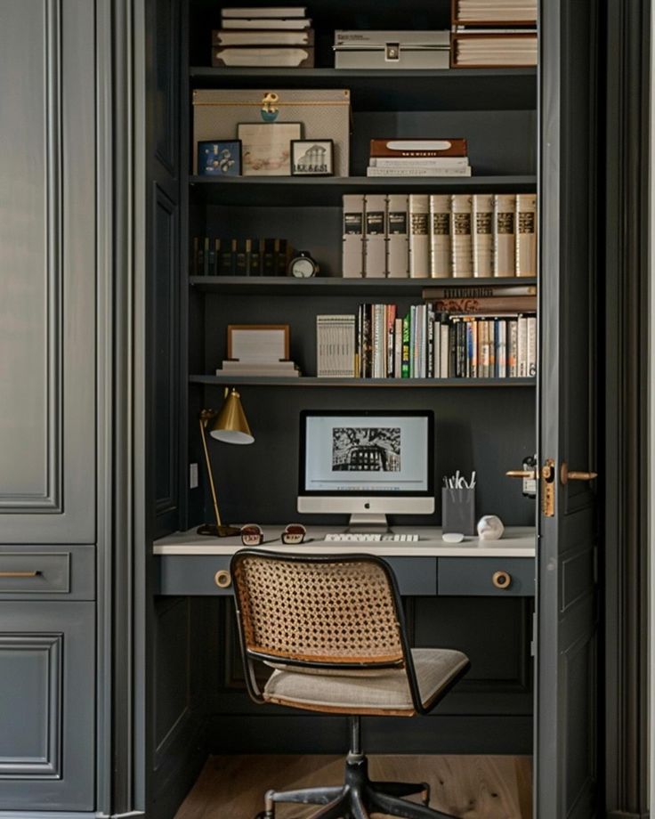 a chair sitting in front of a computer on top of a desk next to a bookshelf