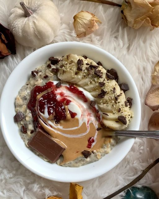 a bowl filled with oatmeal, bananas and peanut butter next to pumpkins