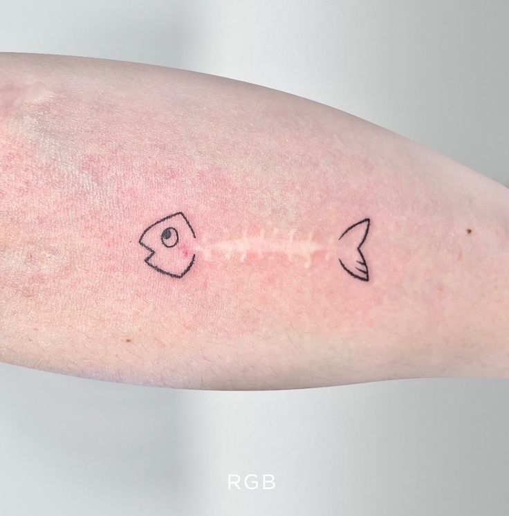 a person's arm with two small tattoos on the left side of their arm