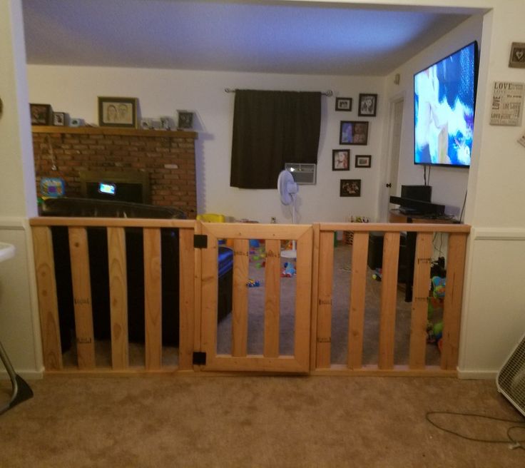 a living room with a flat screen tv mounted on the wall and wooden railings