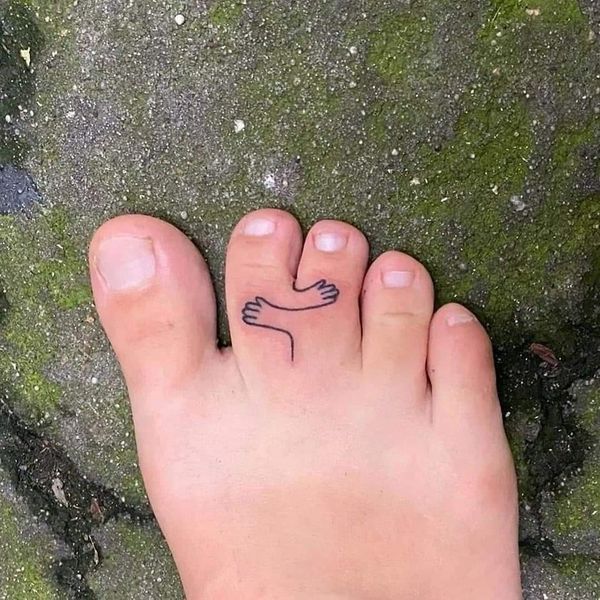 a person's foot with a small tattoo on it