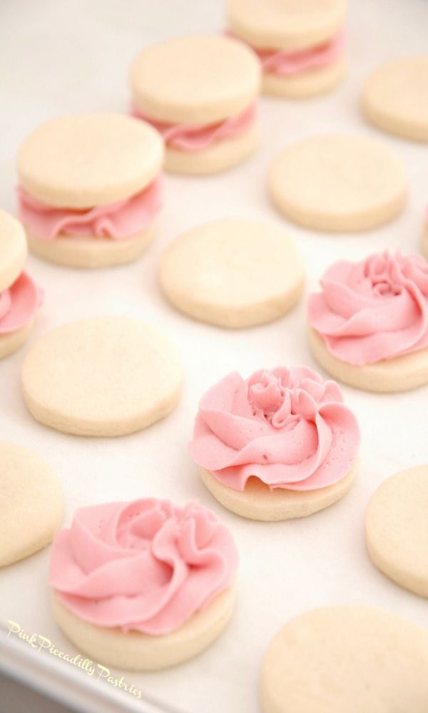 pink and white cookies with frosting on them are arranged in a circle, ready to be eaten