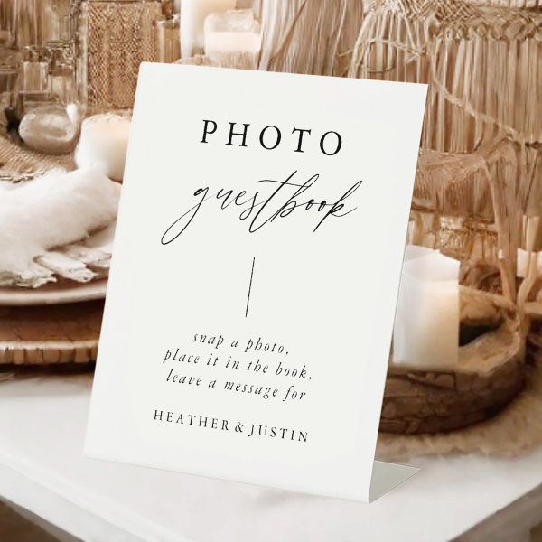 a table topped with plates and candles next to a white sign that says photo guest