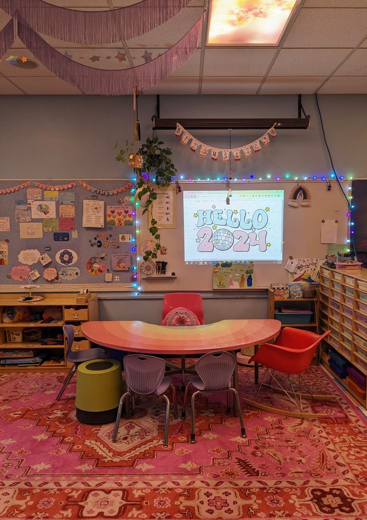 a classroom with tables, chairs and a projector screen on the wall above it