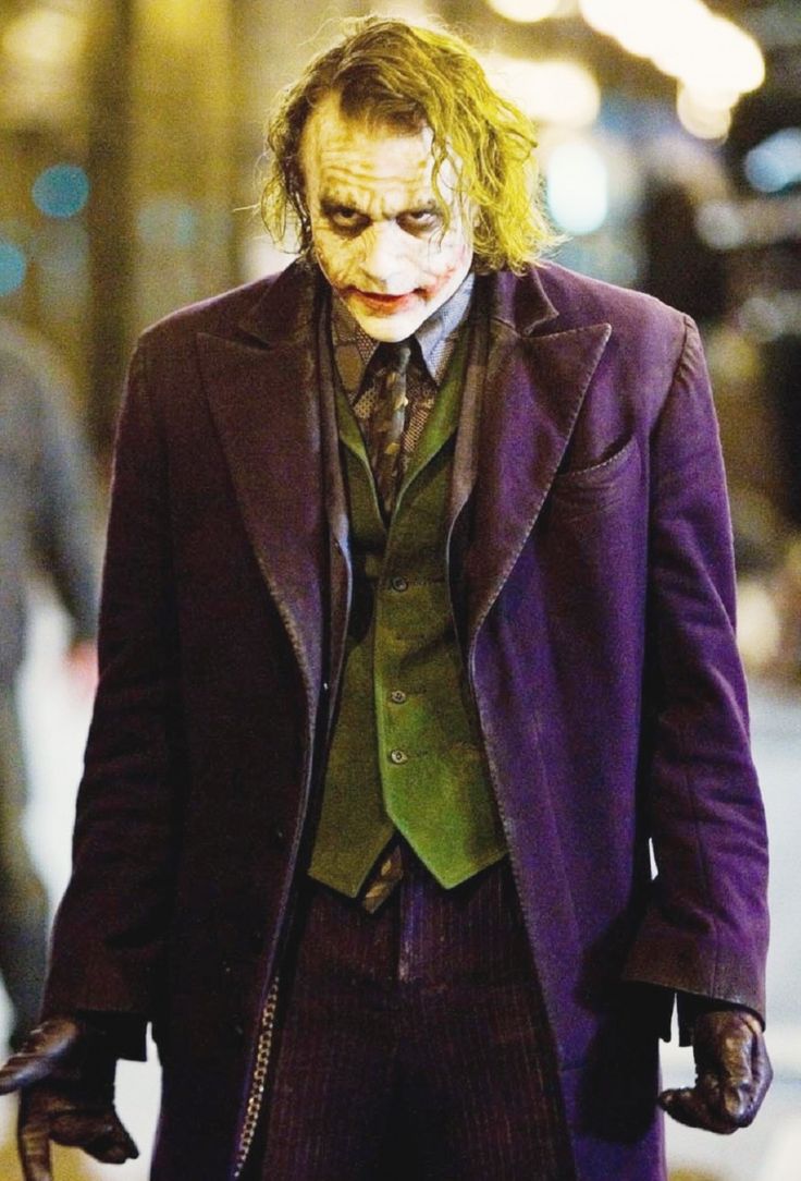 the joker is walking down the street at night