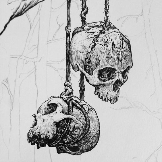 two human skulls hanging from ropes in front of a tree branch with no leaves on it