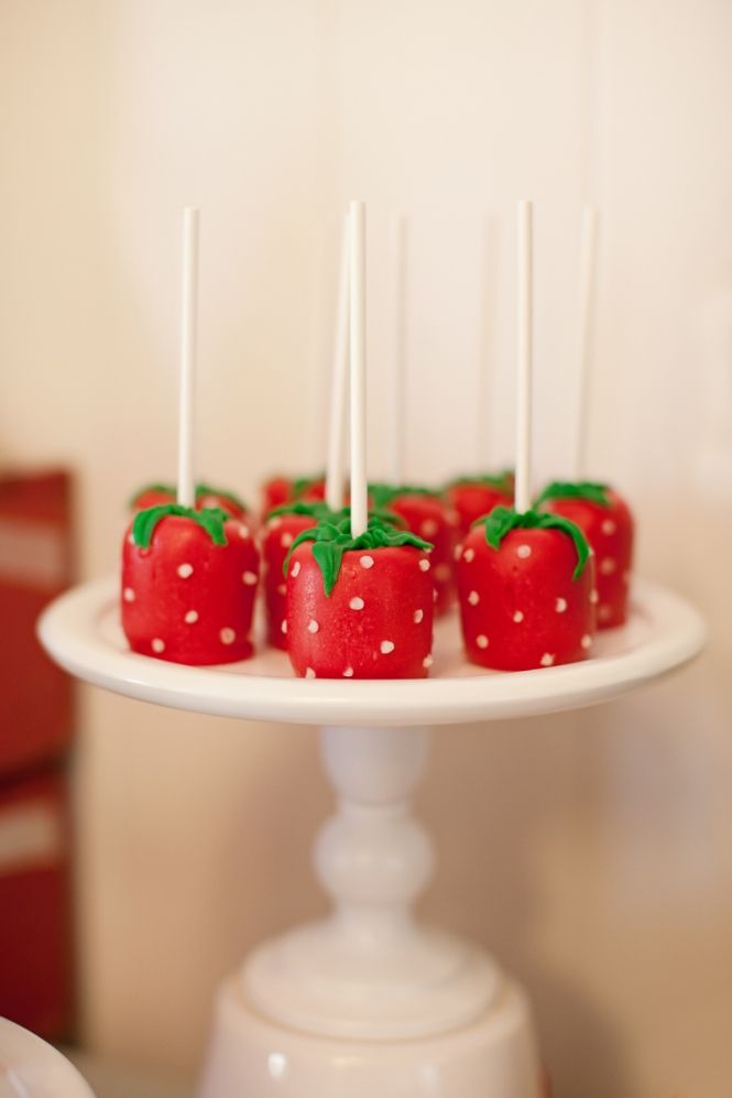 strawberries are arranged on a cake plate with toothpicks sticking out of them