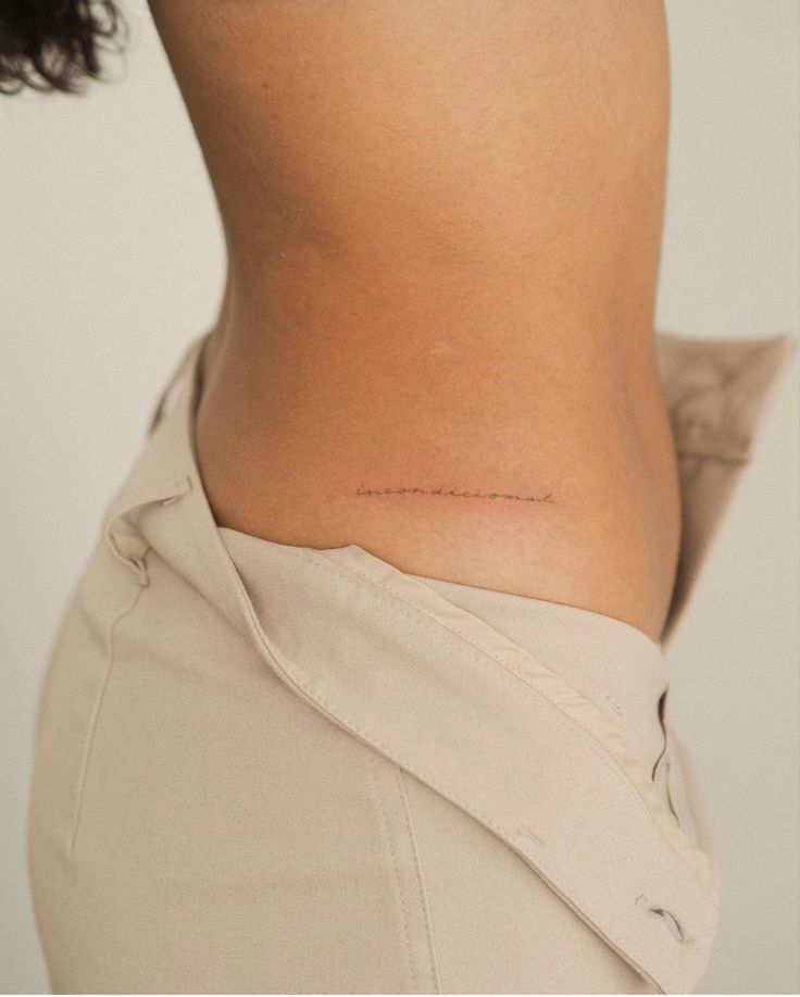 a woman's lower back with the word love written on it