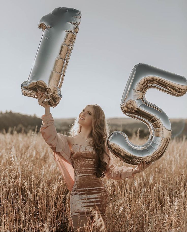 a woman in a dress holding up two large silver balloons that say 35 and the number fifty five