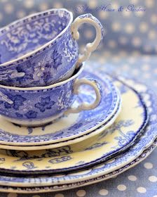 blue and white dishes stacked on top of each other with polka dot tablecloth in the background