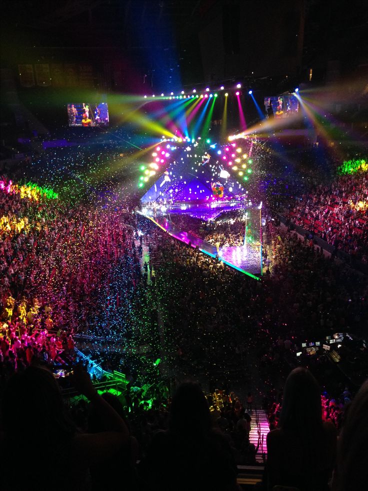 a large crowd at a concert with bright lights