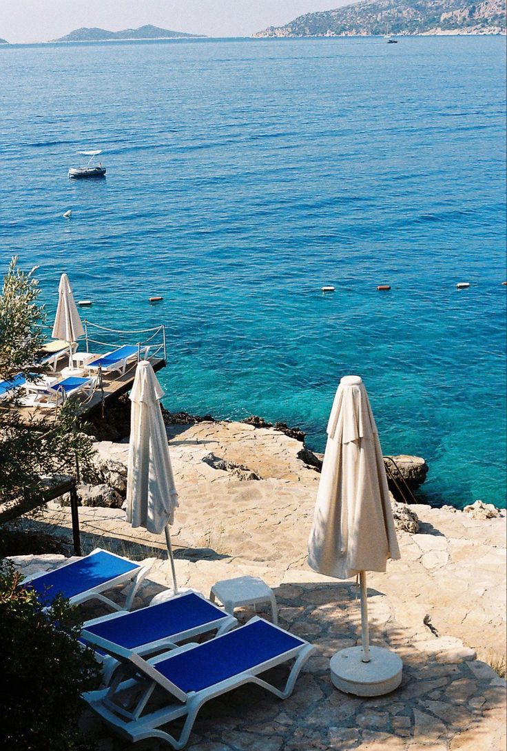 lounge chairs and umbrellas are on the beach