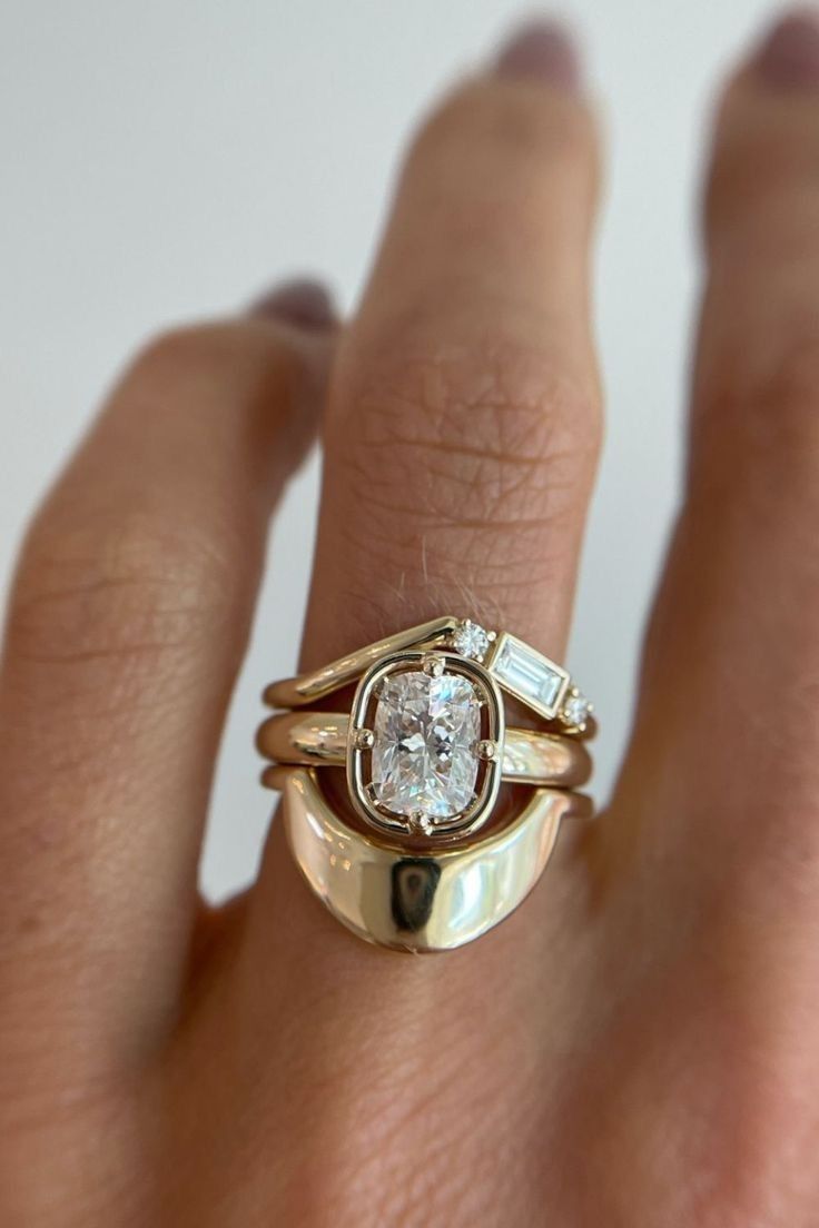 a woman's hand with a gold and diamond ring on top of her finger